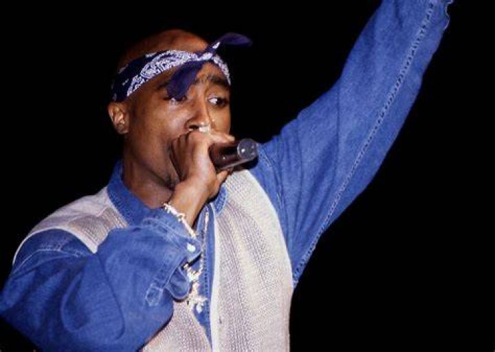 Tupac Shakur with a microphone on stage